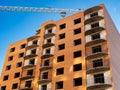 Brick multistory building under construction with crane on the site Royalty Free Stock Photo