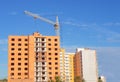 Brick multistory building under construction with crane on the site, new condominium on background Royalty Free Stock Photo