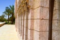 old ancient carved Arab Islamic Islamic wall with ornaments and patterns against the background of green tropical palm trees. The Royalty Free Stock Photo