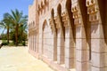 Brick old ancient carved Arab Islamic Islamic wall with ornaments and patterns against the background of green tropical palm Royalty Free Stock Photo