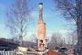 Brick oven with a pipe from the burnt house. Ruins after the fire of a wooden house. High pipe from the furnace against the blue s