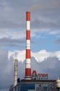 Brick pipe of a heating plant over a city street against a cloudy sky. Russia Krasnoyarsk October 2022. Royalty Free Stock Photo