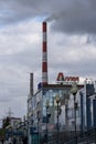 Brick pipe of a heating plant over a city street against a cloudy sky. Russia Krasnoyarsk October 2022. Royalty Free Stock Photo