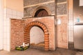 Brick pizza oven with open fire chamber in rustic kitchen setting Royalty Free Stock Photo