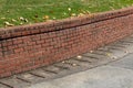 Brick retaining wall with green grass and concrete driveway, residential Royalty Free Stock Photo