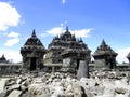 Brick stone blocks and rock ruins with gates of Plaosan Temple Candi behind, with blue sky and white clouds at Klaten, Indonesia