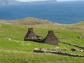 Brick stone structures in the Riasg Buidhe village, the Shetland with fresh grass and a sea above Royalty Free Stock Photo