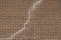 Brick texture with vertical crack in mortar joint. Wall crack problem for foundation repair concept. Damaged brick facade with Royalty Free Stock Photo