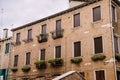 Closeup of the facade of a building, on the streets of Venice, Italy. A three-story brick building with closed brown Royalty Free Stock Photo