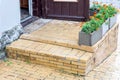 Brick threshold with a step at the open wooden entrance door.