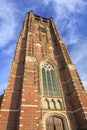 Brick tower of Saint Michel church against cloudy blue sky, Ravels, Flanders, Belgium