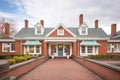 brick walkway approaching a colonial revival home with dormers