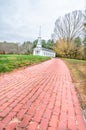 Brick walkway leading to old, white New England church in the distance Royalty Free Stock Photo