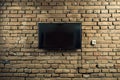 brick wall backdrop with a mounted flatscreen for presentations