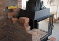 Brick wall border for a wood-burning stove or fireplace under construction in the interior fitting area Royalty Free Stock Photo