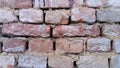 Brick wall. Ceramic brickwork or fence. Old, uneven brick, covered in some places with moss. Texture of crumbling stone Royalty Free Stock Photo