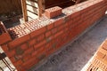 Brick wall construction in progress at a building site during daylight hours Royalty Free Stock Photo