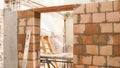 Brick wall of a construction site with a ladder in the background Royalty Free Stock Photo