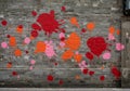 A brick wall covered in colorful paint splatters in red, orange, and pink. The paint Royalty Free Stock Photo