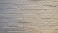 The brick wall is covered with a layer of white paint in light yellow lighting Royalty Free Stock Photo
