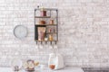 Shelf with kitchenware on brick wall