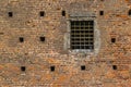 Brick wall exterior view with iron grid window