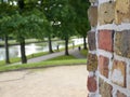 A brick wall in front of a park with trees Royalty Free Stock Photo