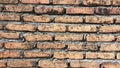 A brick wall with a gray cement base. The wall is made of red bricks and has a rough texture Royalty Free Stock Photo