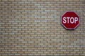 Brick wall of gray and yellow bricks with a red road stop sign. rough surface texture Royalty Free Stock Photo