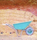 straw hay bales and wheel barrow brick wall farm