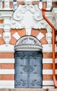 Brick wall of historical building, stucco molding, wrought iron door Royalty Free Stock Photo