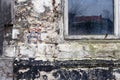 Brick wall with layers of weathered stucco.