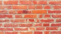 Brick wall made of bright red bricks. Lightly worn surface. Neat masonry, cement between the rows. Grunge background. The exterior Royalty Free Stock Photo