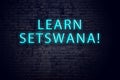 Brick wall and neon sign with inscription. Concept of learning setswana