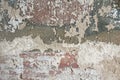 Old flaky white paint peeling off a grungy cracked wall. Cracks, scrapes, peeling old paint and plaster on background of old Royalty Free Stock Photo