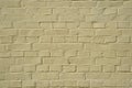 Brick wall outside, faded yellow paint. Texture background Royalty Free Stock Photo