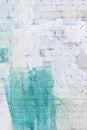 The brick wall is painted abstractly with white and green paint. Background in the divorce, texture. Royalty Free Stock Photo