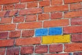 The brick wall is painted in the colors of the Ukrainian flag. Part of the wall of a 19th century building made of old Royalty Free Stock Photo