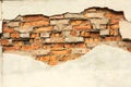 Brick wall with partially destroyed plaster, background or texture