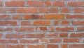 Brick wall of red-orange bricks and blocks. Lightly worn surface. Neat masonry, cement between the rows. Grunge background. Royalty Free Stock Photo