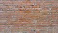 Brick wall of red-orange bricks and blocks. Lightly worn surface. Neat masonry, cement between the rows. Grunge background. Royalty Free Stock Photo