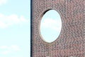 Brick wall with round window against blue sky background Royalty Free Stock Photo