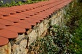 Brick wall of stone blocks of yellow color. the roof of the wall made of burnt tiles protects the crown from the soaking of rain a Royalty Free Stock Photo