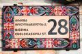 Brick wall with stylish ornamental house number and street name sign in old town Telavi. Bidzina Cholokashvili street of