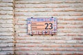 Brick wall with stylish ornamental house number and street name sign in old town Telavi. Bidzina Cholokashvili street of