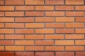 Brick wall texture. Red brick. Laying from rows of stone blocks. Simple ginger background in loft style. A repeating element. A