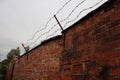 Brick wall with three rows of barbed wire installed