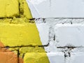 Brick wall with traces of paint. Background with white brick wall painted yellow and white closeup Royalty Free Stock Photo