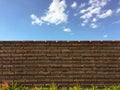 Brick wall with white clouds in blue sky. blue skies over red brick wall. shrubs and brick fence on blue sky background. Royalty Free Stock Photo