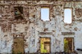 Brick wall with window openings of old abandoned dilapidated residential building